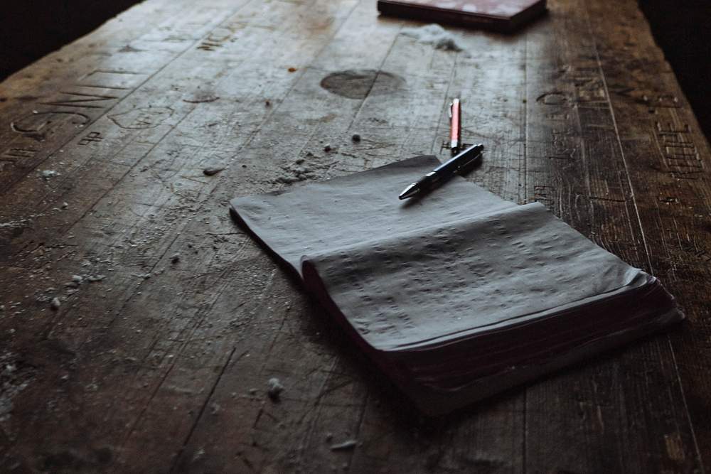 Journal on a wooden table in a forest cabin