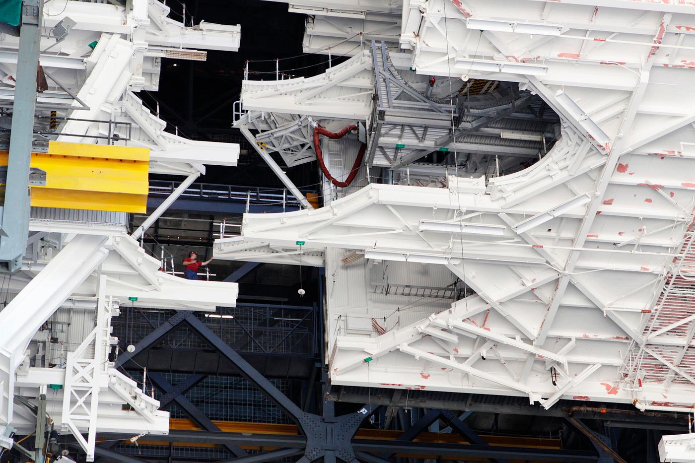 At NASA’s Kennedy Space Center in Florida, a crane lowers a space shuttle-era work platform from high bay 3 inside the... At NASA’s Kennedy Space Center in Florida, a crane lowers a space shuttle-era work platform from high bay 3 inside the...