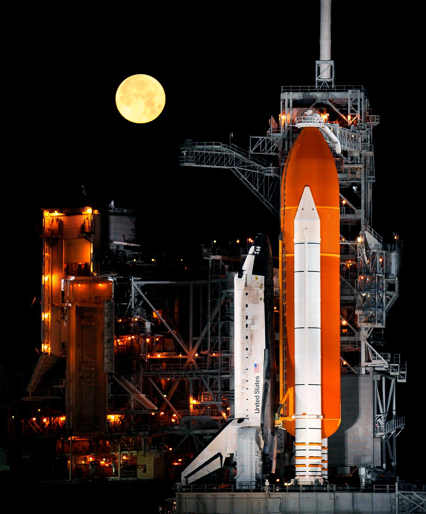A nearly full Moon sets as the space shuttle Discovery sits atop Launch pad 39A at the Kennedy Space Center in Cape... A nearly full Moon sets as the space shuttle Discovery sits atop Launch pad 39A at the Kennedy Space Center in Cape...