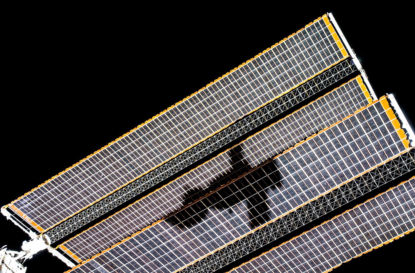 The shadow of the Soyuz TMA-14 spacecraft is visible against solar array panels of the International Space Station during... The shadow of the Soyuz TMA-14 spacecraft is visible against solar array panels of the International Space Station during...
