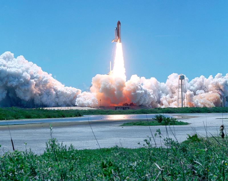 Rocket launch KENNEDY SPACE CENTER, FLA. - Smoke and steam billow across Launch Complex 39B as the launch of Space Shuttle Discovery on…