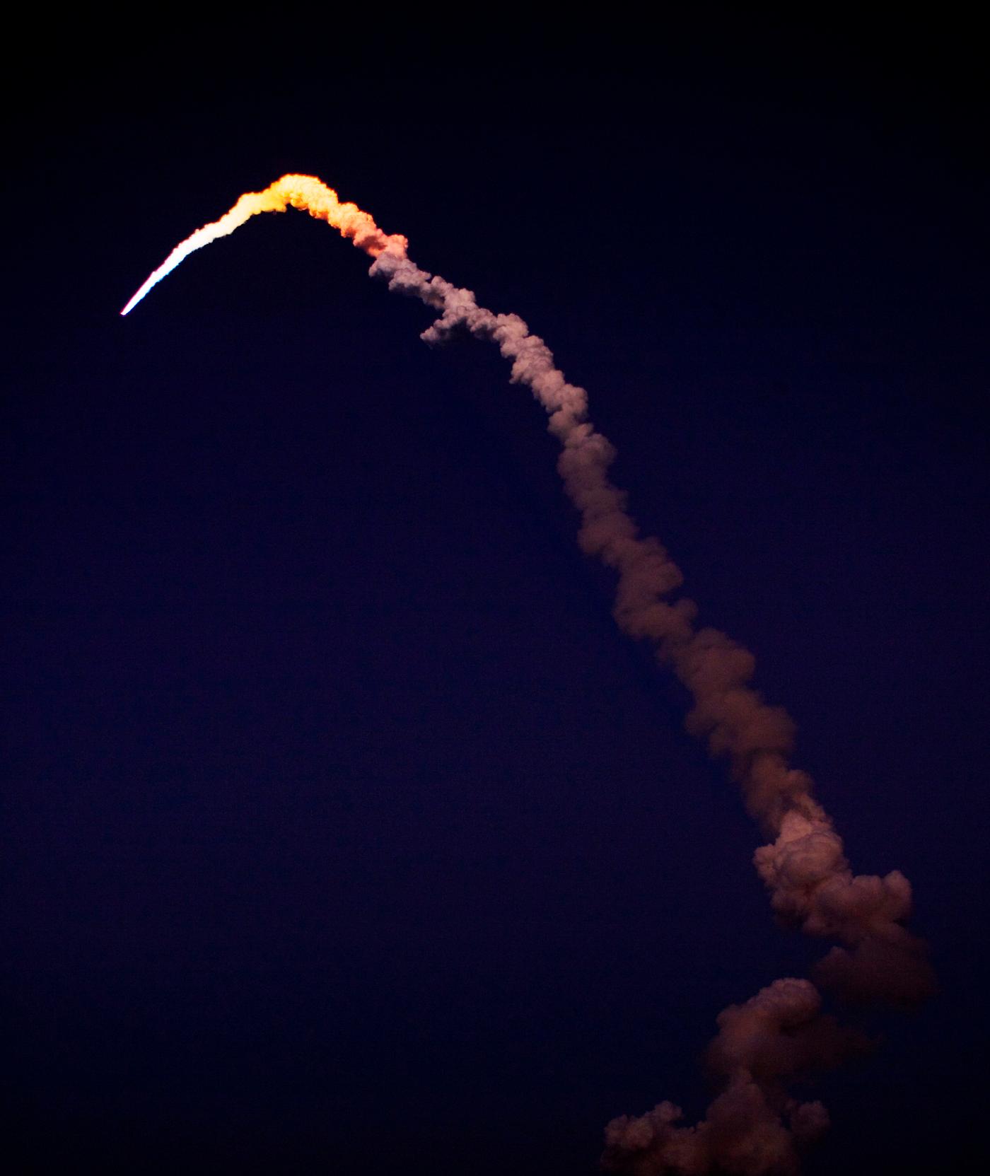 As it arcs into space, space shuttle Discovery is lighted by sunlight after leaving the darker skies over NASA's Kennedy... As it arcs into space, space shuttle Discovery is lighted by sunlight after leaving the darker skies over NASA's Kennedy...
