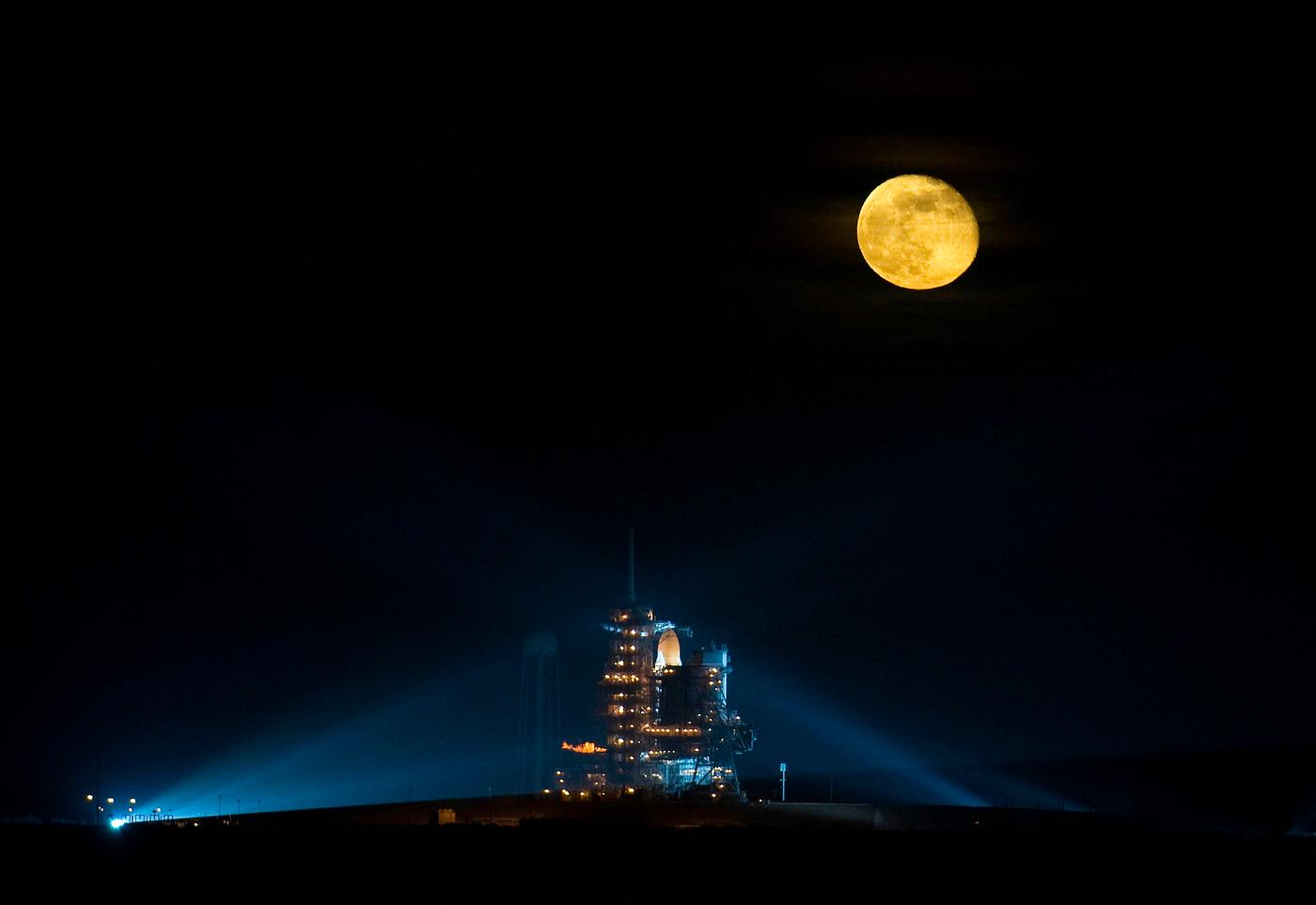 The moon is seen rising behind the Space Shuttle Endeavour on pad 39A. Original from NASA. Digitally enhanced by rawpixel. The moon is seen rising behind the Space Shuttle Endeavour on pad 39A. Original from NASA. Digitally enhanced by rawpixel.