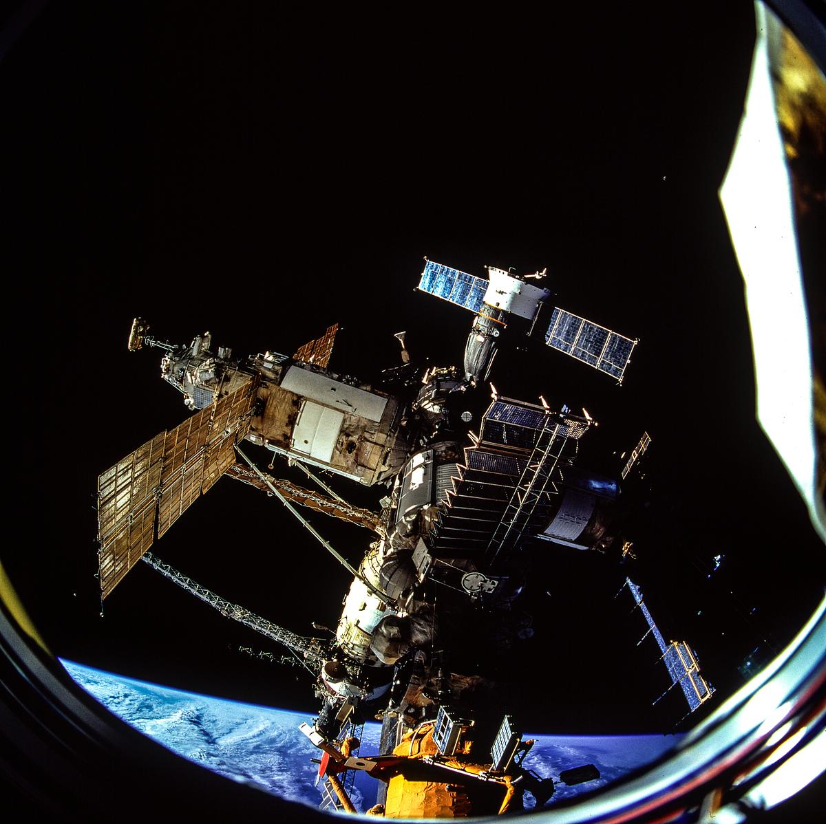 The docked Russian Mir Space Station is… | Free public domain photo The docked Russian Mir Space Station is partially visible through the Spacehab viewing port. Original from NASA. Digitally…