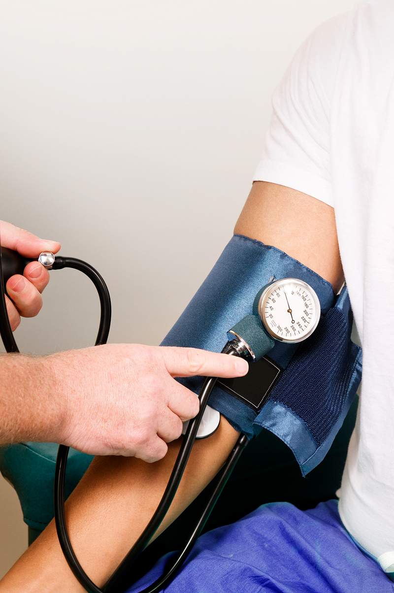 Female clinician in the process of conducting a blood pressure examination on a patient. Original image sourced from US…
