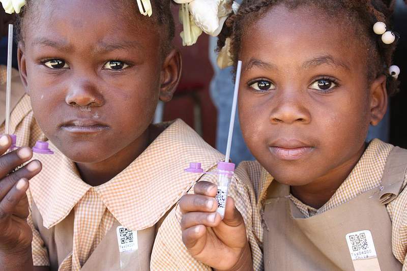 Children holding vaccination tube waiting to get vaccinated. Original image sourced from US Government department: Public…