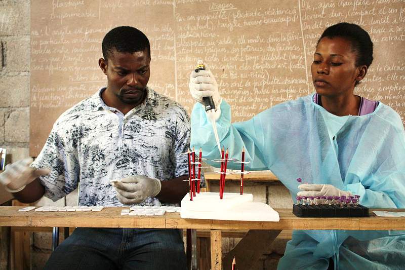 Two laboratory technicians experimenting with virus. Original image sourced from US Government department: Public Health…