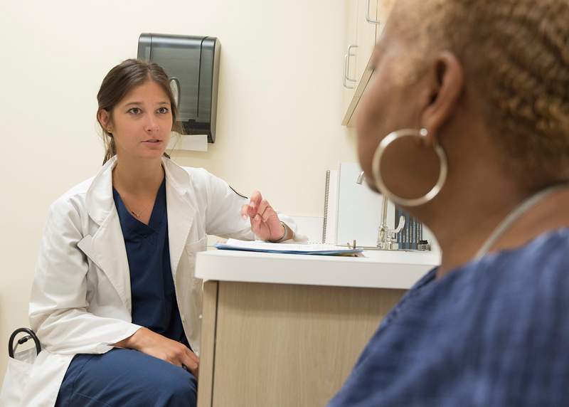 Stock image of a doctor listening to her patient in a doctor's office.