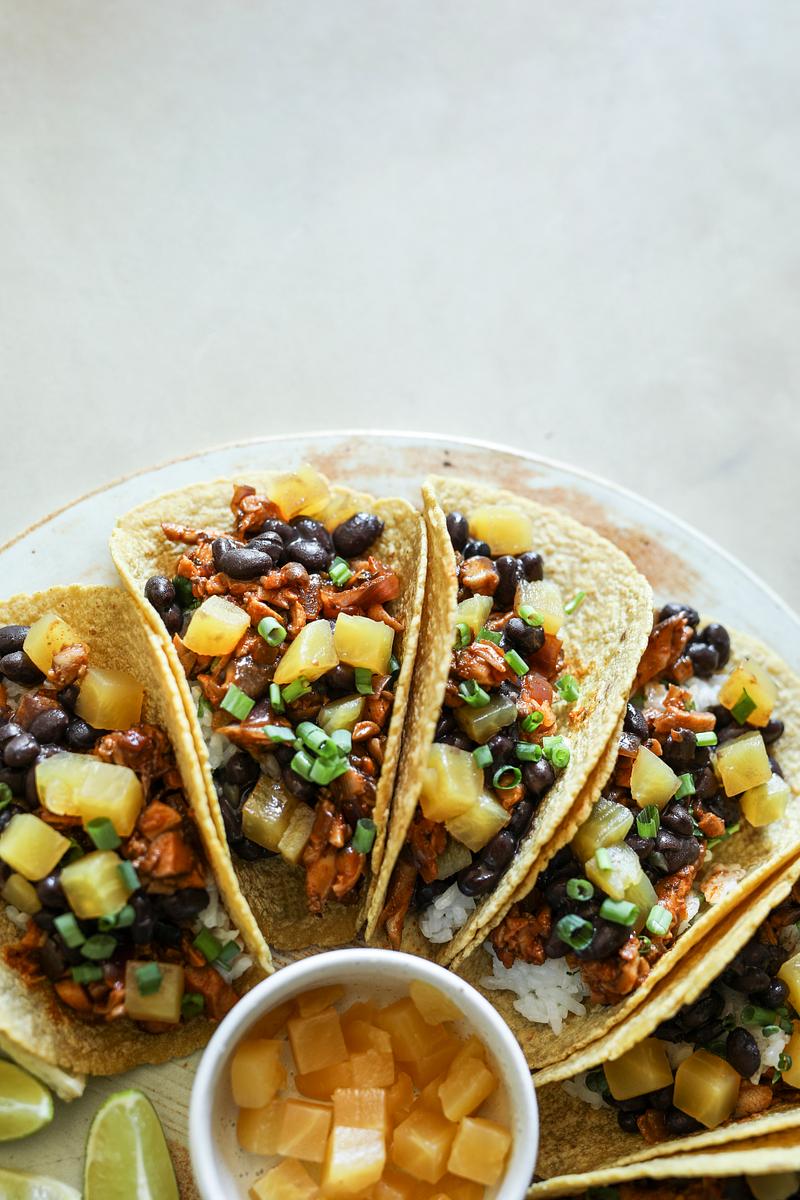 Vegan jackfruit tacos with fresh toppings on a wooden table