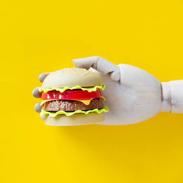 The Beginner's Guide to A.I. in Restaurants: Increase Your Sales Using Artificial Intelligence 4 Robot hand holing a hamburger