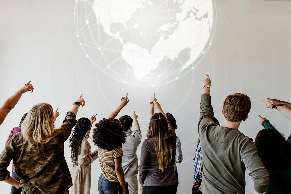 Rearview of diverse people pointing to a global network symbol 