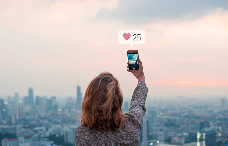 Woman taking a photo of the sunset