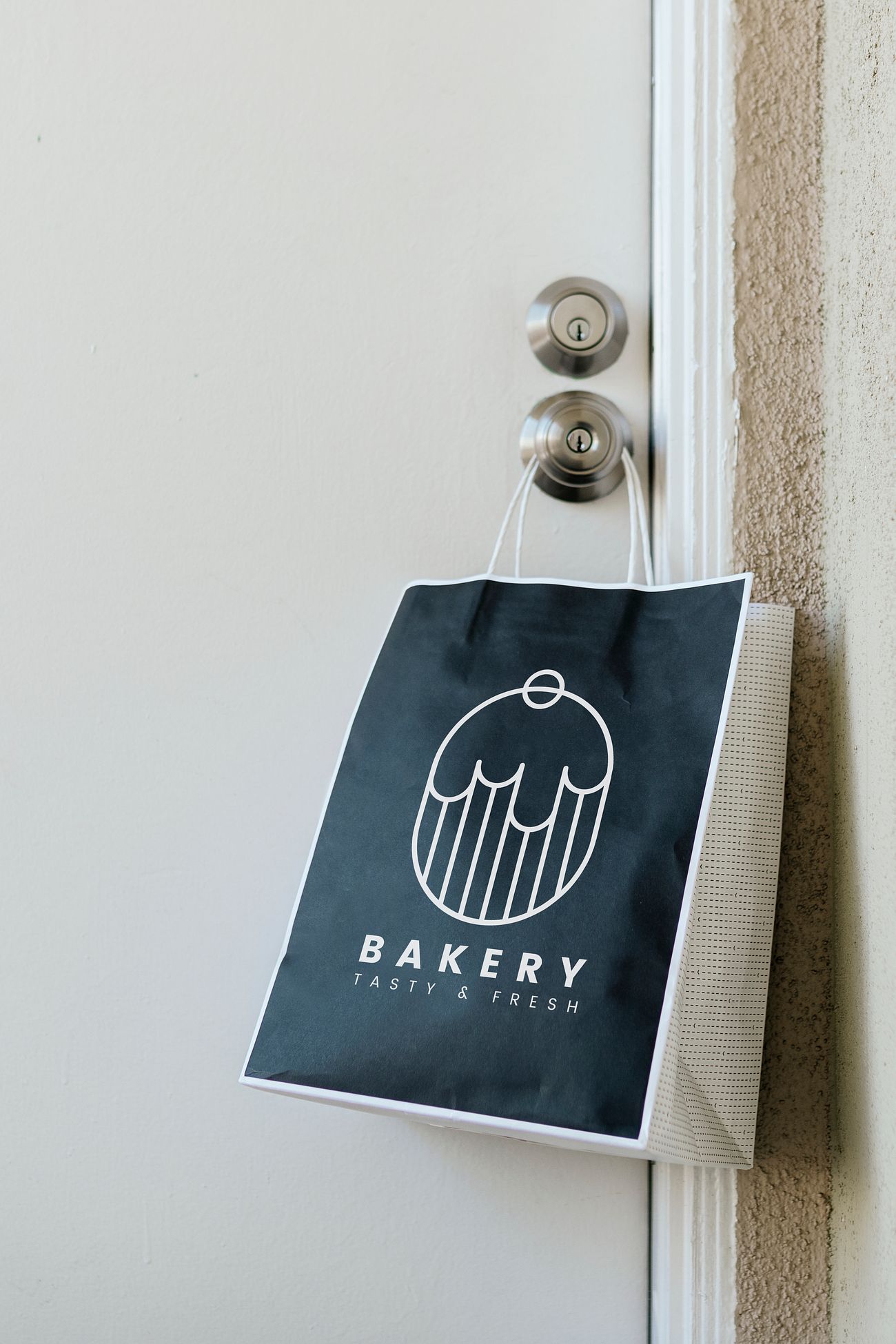 Download Contactless delivery bakery bag mockup hanging on a doorknob during th.. | Free psd mockup - 2330037