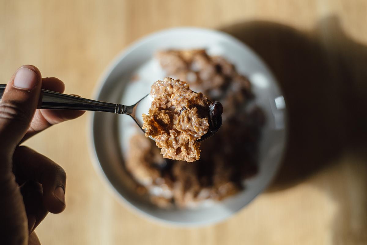 A person holding a spoon full of cereal over… | Free public domain photo A person holding a spoon full of cereal over a bowl of cereal and milk. Original public domain image from Wikimedia Commons