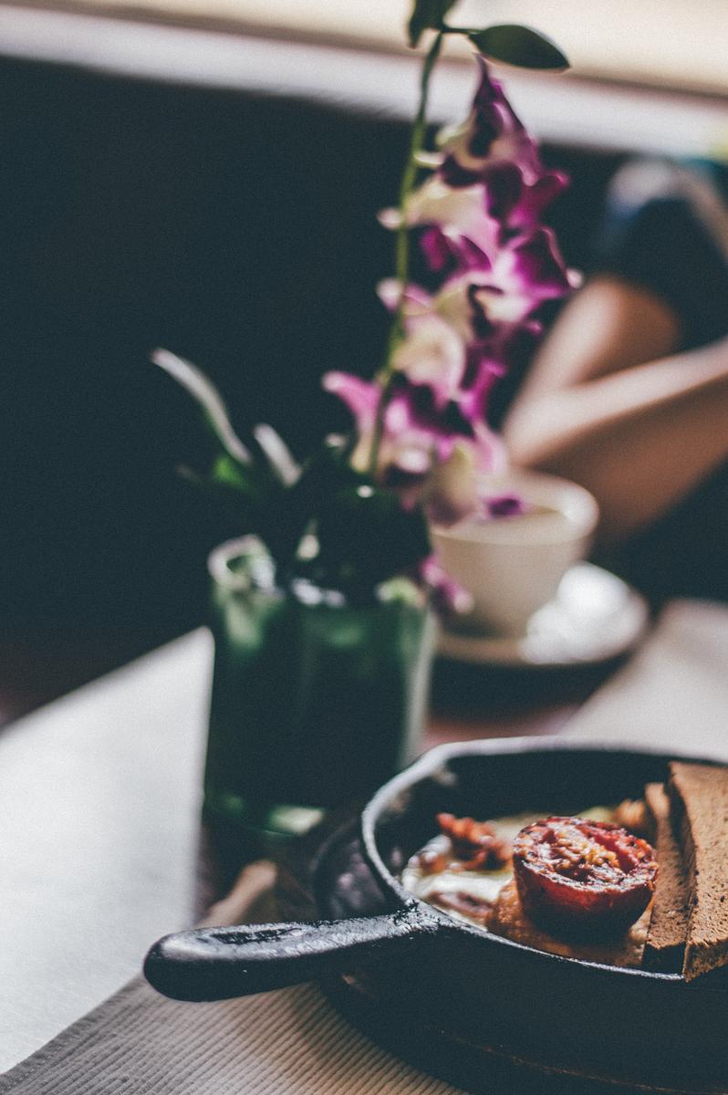 A blurry shot of a skillet with a fried… | Free public domain photo A blurry shot of a skillet with a fried tomato and bread next to a flower vase on a table. Original public domain image from…